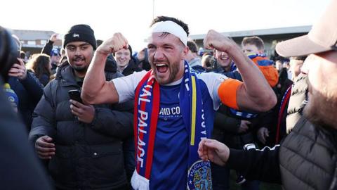 macclesfield captain paul dawson celebrating with fans on the pitch after the macclesfield game against crystal palace