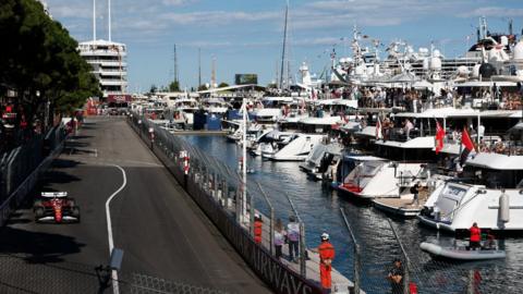 Charles Leclerc drives past the yachts in the Monaco harbour 