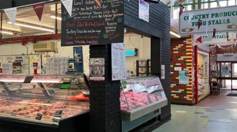 Image shows a butcher's stall at Birkenhead indoor market