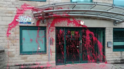 Red paints spattered across the entrance to an apartment block