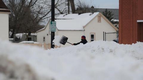 A man clears his sidewalk along South Park Avenue on December 28, 2022 in Buffalo, New York