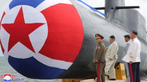 North Korean leader Kim Jong Un attends what state media report was a launching ceremony for a new tactical nuclear attack submarine in North Korea