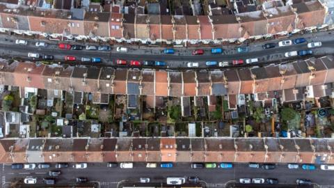 An aerial drone photo showing rows of housing in Bristol and streets lined with cars. 