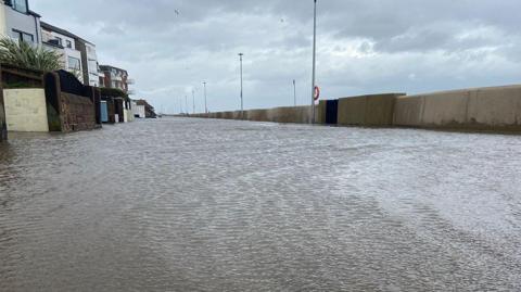 A flooded South Parade in West Kirby showing water flooding the promenade