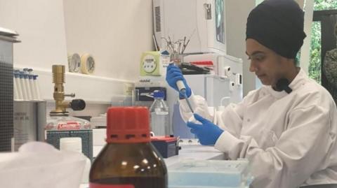 A view of a researcher preparing samples to be analysed in a machine.
