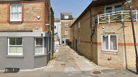 A Google Street image of Mansion Street in Margate, which is a single-track alleyway between two buildings.