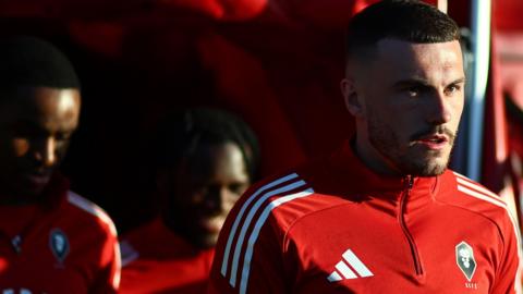 Salford City players walk on to the pitch for their pre-match warm-up