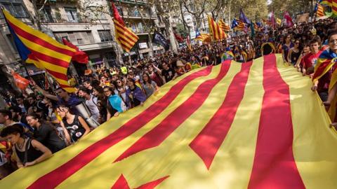 Crowds of people with Catalan flags marching