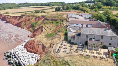 The Anchor's Drop pub shown from above with the nearby coast line clearly visible