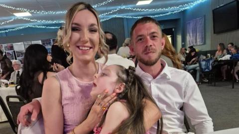 Catrin yn dal ei merch Eva Rae