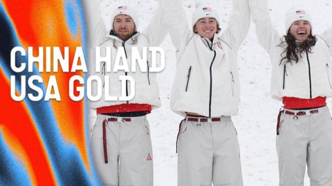 The winning USA aerial team join hands and hold them above their heads as they celebrate winning gold.