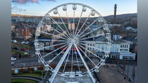 Aerial view of the white observation wheel, with Darwen in the background