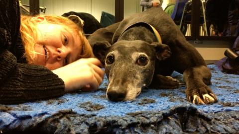 A student lying next to a dog