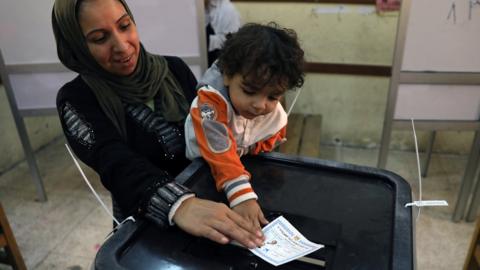 Egyptian woman and her child cast a ballot in the presidential election in Cairo on 26 March 2018