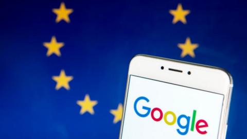 The Google logo on a smartphone with the EU flag in the background