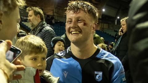 Evan Lloyd smiles while greeting young Cardiff fans