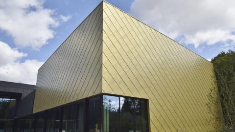 Part of ARU Peterborough's new lab - a futuristic square-shaped building with gold tiles. 