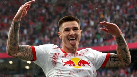 Benjamin Sesko raises his arms in celebration after scoring for RB Leipzig