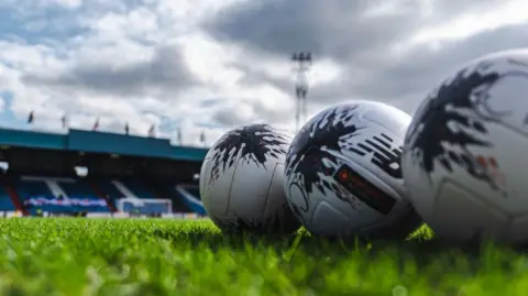 Three National League footballs at a National League ground