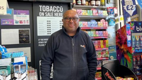 Mayank Parikh standing behind his shop counter