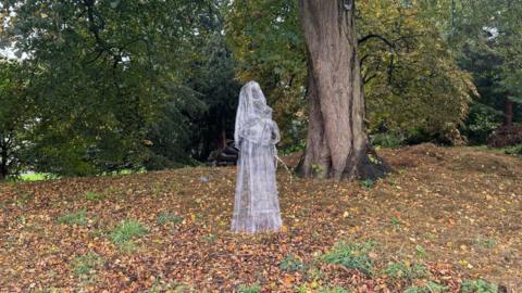 A wire statue depicting a nun with rosary beads in York Museum Gardens