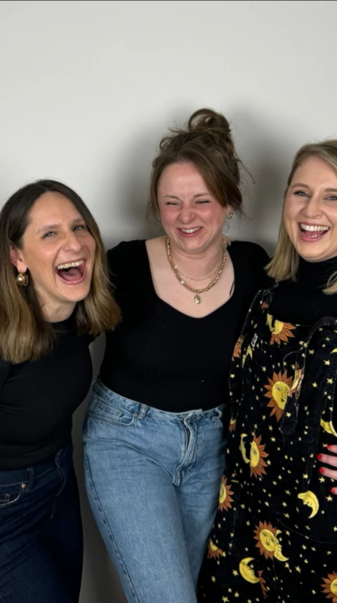 Three women standing together smiling
