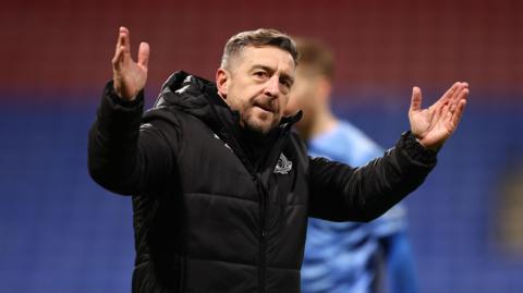 Port Vale manager Job Brady acclaims the crowd after a win 