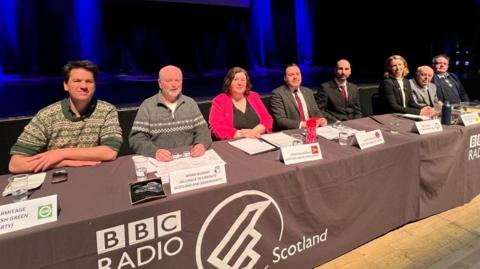 Eight candidates sitting at a table with the BBC Radio Scotland logo