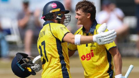 Jack Hope-Bell of Glamorgan, right, celebrates with Alex Horton of Glamorgan, as he reaches his maiden 100 runs