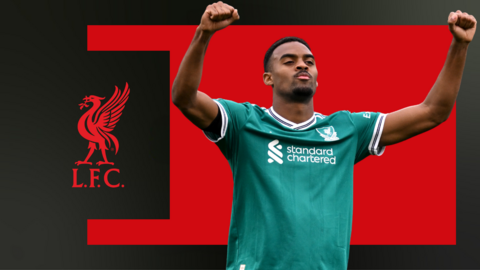 Ryan Gravenberch with both arms in the air saluting the Liverpool fans, against a red and black background with the club crest to his side