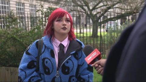 A student with red hair and wearing a blue fleece is interviewed by BBC Wales