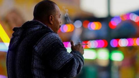 A man smokes in a public plaza in Ciudad Juarez, Mexico, 13 January 2023