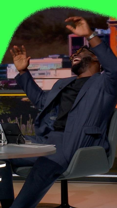 Micah Richards laughing sat in the BBC Sport Studio