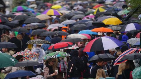 People taking shelter from the rain during the RHS Chelsea Flower Show