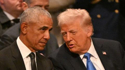 Obama and Trump lean in to each other talking