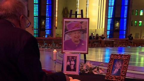 Man signing book of condolence in cathedral