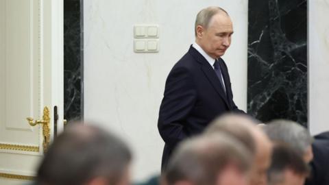 Putin walking in meeting