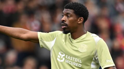 Tyreeq Bakinson wearing the lime green Leyton Orient shirt.