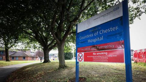 A sign at the entrance to the Countess of Chester Hospital says 'Welcome to Countess of Chester Hospital, accident and emergency and Countess of Chester NHS Foundation Trust'.