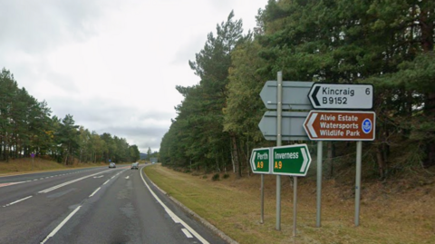 A shot of the A9 facing southbound at the Aviemore junction. Road signs for Kincraig and Alvie Estate Watersports Wildlife Park point towards the junction, which is just out of frame.