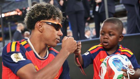 Spain football player Lamine Yamal and his younger brother fist bump.
