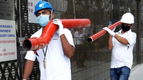 Workers carrying pipes