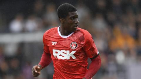 Micah Mbick running while turning his head over his left shoulder during a match for Charlton