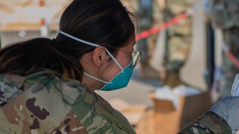 A US Air Force Airwoman checks the temperature of an evacuee at Ramstein Air Base, Germany