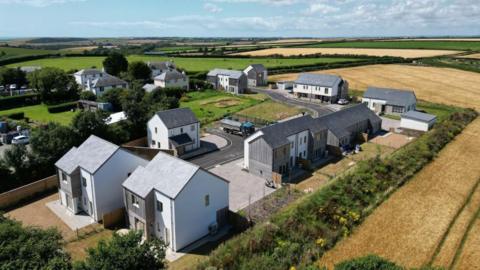 Aerial view of Holywell Meadow in Bigbury. There houses at the centre with fields and hedges surrounding it. 