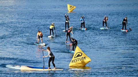 Multiple paddle borders on the water navigating a course