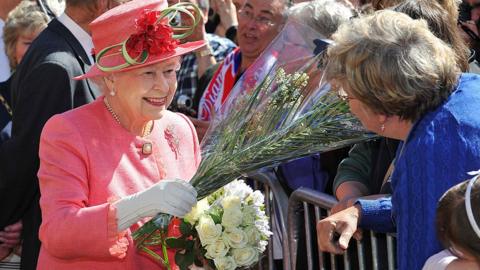 Queen Elizabeth II receives flowers from members of the public in Victoria Square during her Diamond Jubilee visit to the City on July 12, 2012 in Birmingham