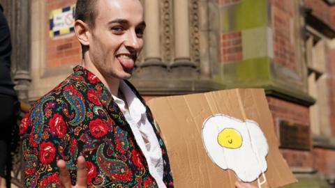 Patrick Thelwell arriving at York Magistrates' Court holding up an egg sign