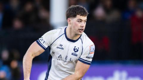 Sam Worsley holding a ball to his right side in both hands during a match for Bristol 