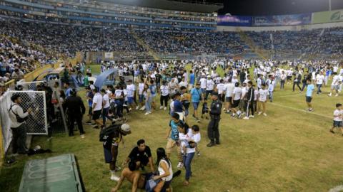 Supporters are helped by others following a stampede during a football match between Alianza and FAS at Cuscatlan stadium in San Salvador